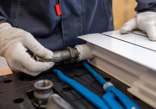 Plumber fitting a pipe connection during an installation job